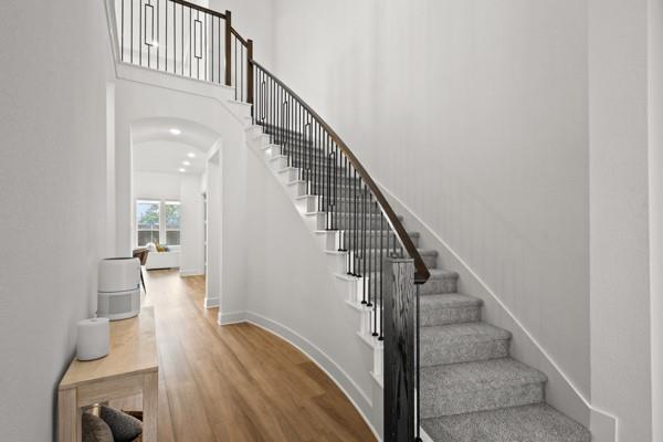 1825 Rough Rdg Trail Midlothian, TX 76065 - Photo 6 of 37 Curved staircase with black metal balusters and wood-finish handrail