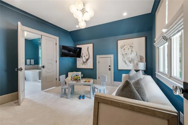 a bedroom with a large bed and a chandelier fan