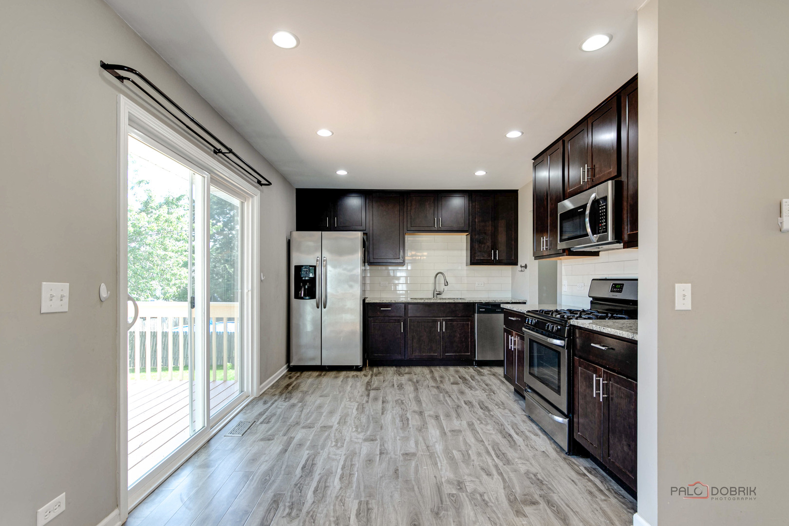 1030 Hassell Road Hoffman Estates, IL 60169 - Photo 3 of 35 a kitchen with stainless steel appliances granite countertop a refrigerator a sink dishwasher a stove and white countertops with wooden floor
