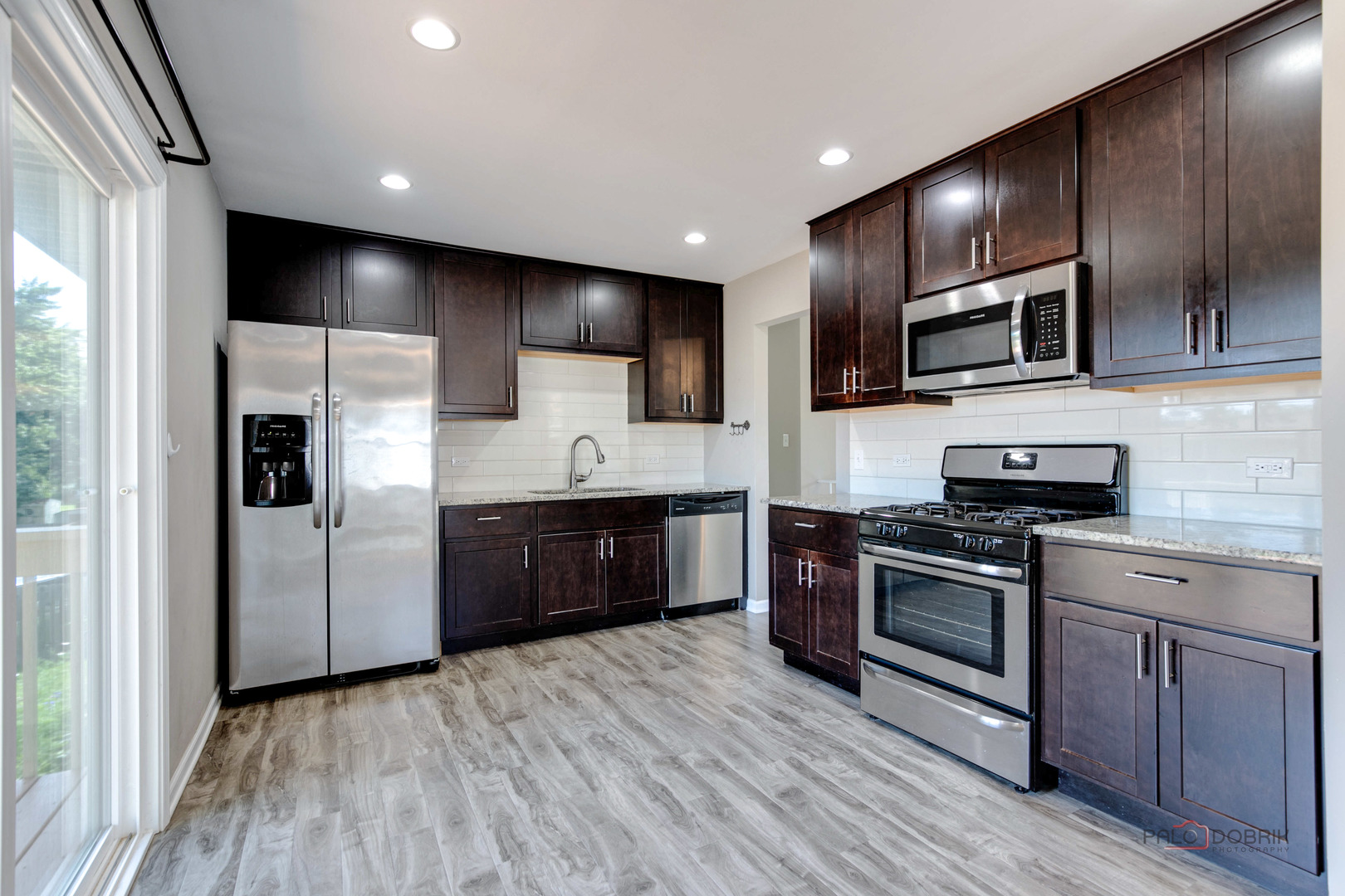 1030 Hassell Road Hoffman Estates, IL 60169 - Photo 7 of 35 a kitchen with stainless steel appliances kitchen island granite countertop a stove a sink and a microwave