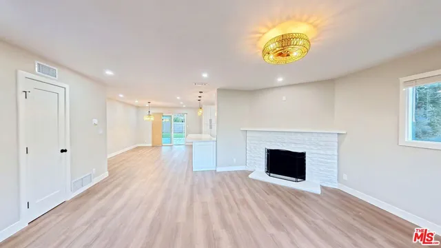 a view of a hallway with wooden floor and a fireplace