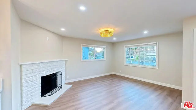 a view of an empty room with a fireplace and a window