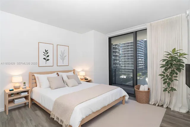 a bedroom with a large bed and a potted plant