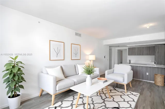 a living room with furniture and a potted plant