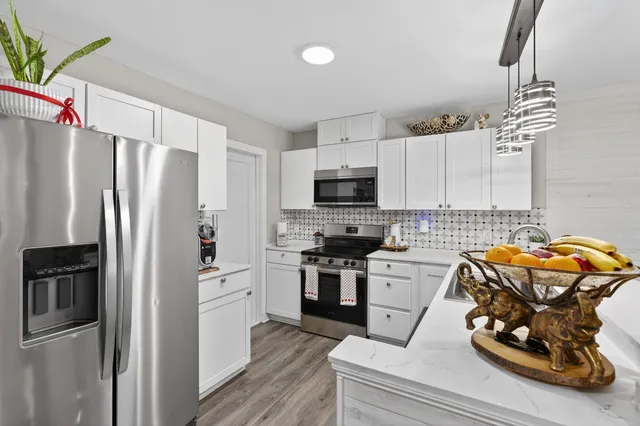 a kitchen with stainless steel appliances a refrigerator sink and microwave