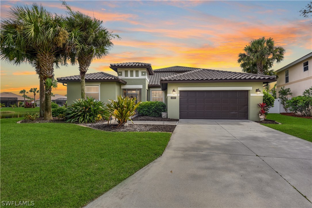 a front view of a house with a garden and palm trees