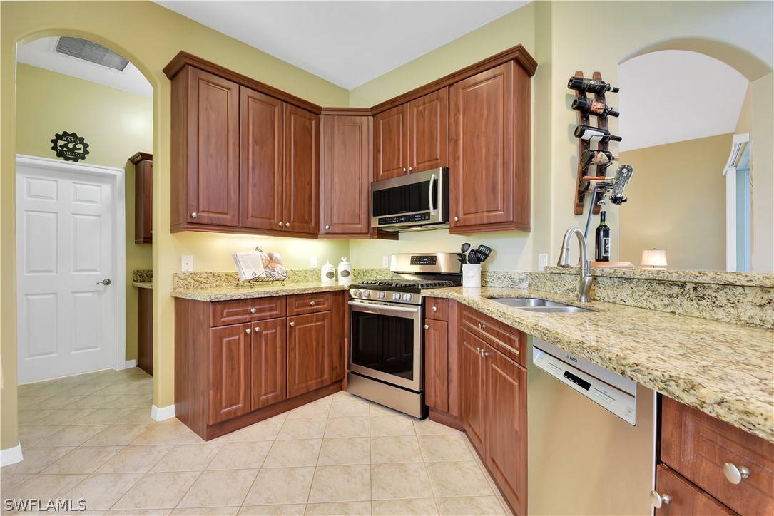 12831 Timber Ridge Drive Fort Myers, FL 33913 - Photo 4 of 16 a kitchen with granite countertop a sink stainless steel appliances and cabinets