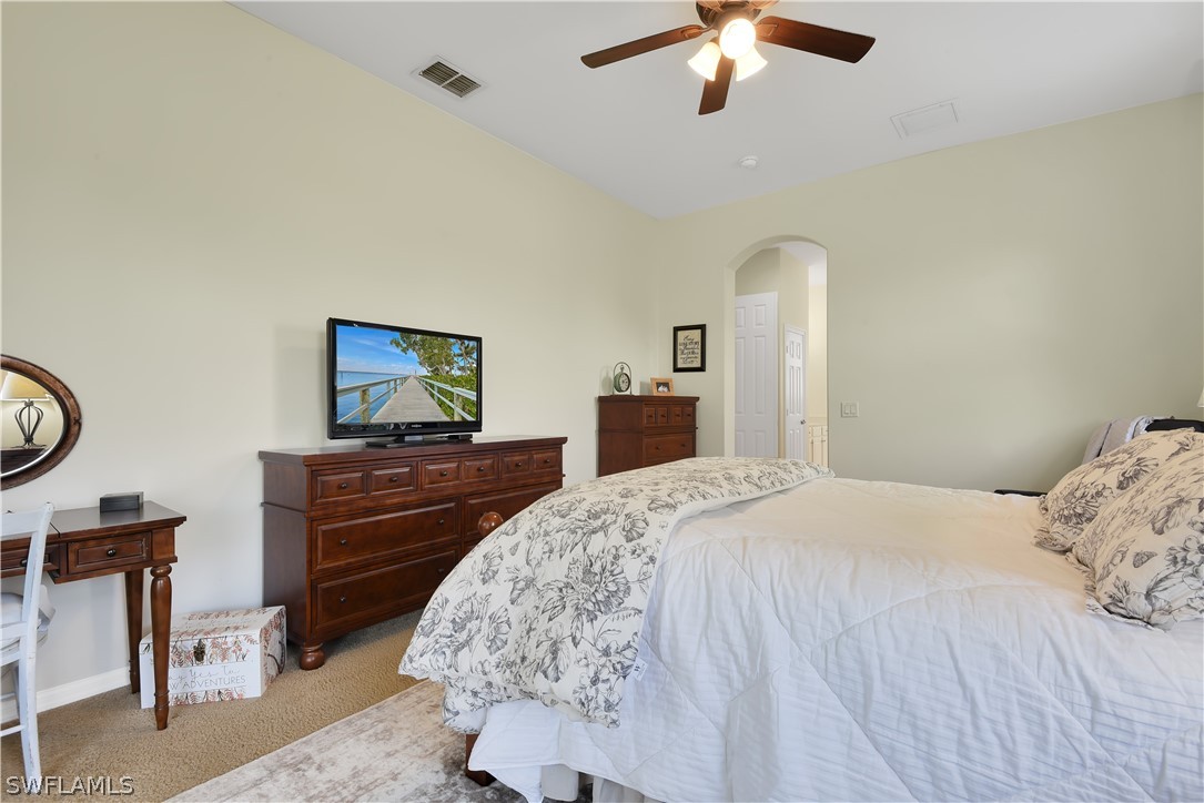 12831 Timber Ridge Drive Fort Myers, FL 33913 - Photo 8 of 16 a bedroom with a bed and a chandelier
