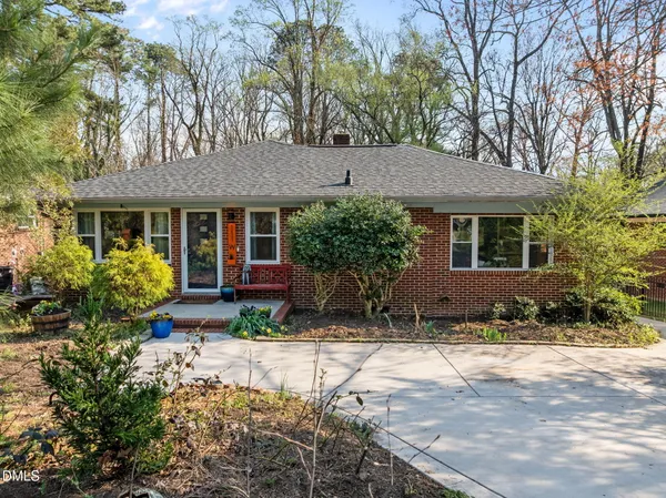 a front view of a house with a yard and a garden