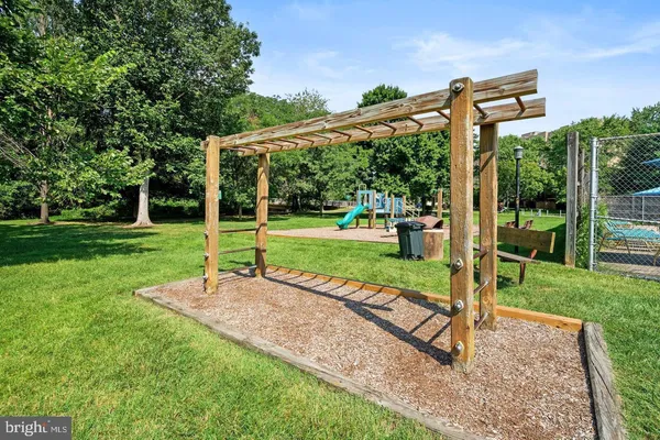 a view of a swimming pool with a bench and trees