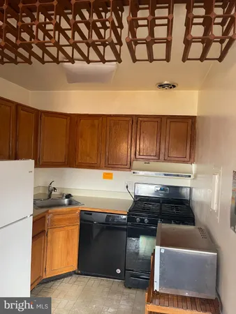 a kitchen with a refrigerator and a stove top oven