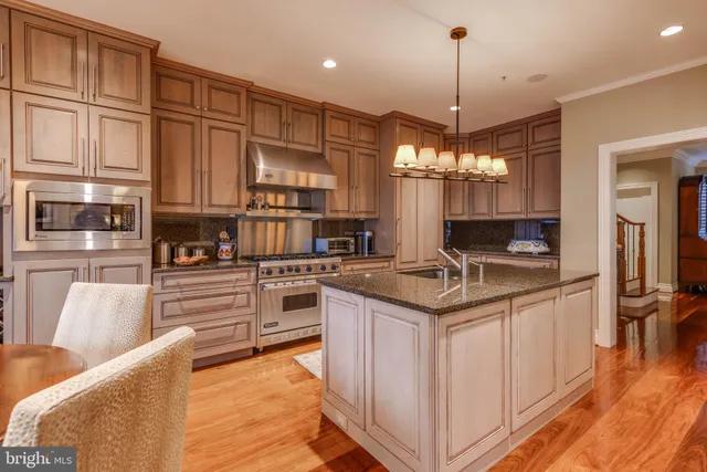 a kitchen with stainless steel appliances granite countertop a sink dishwasher and cabinets with wooden floor