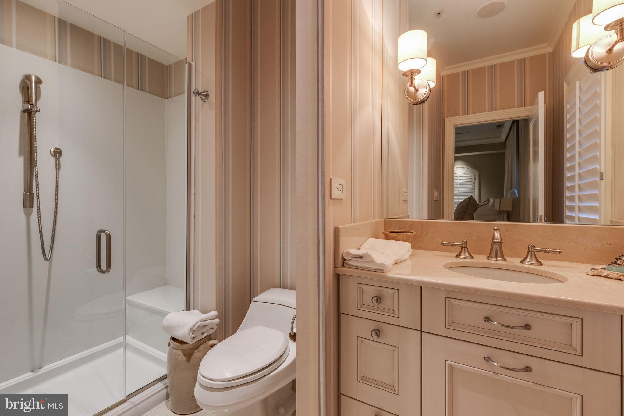 2325 Boston Street, Unit 2 Baltimore, MD 21224 - Photo 43 of 48 a bathroom with a granite countertop sink toilet a mirror a vanity and shower