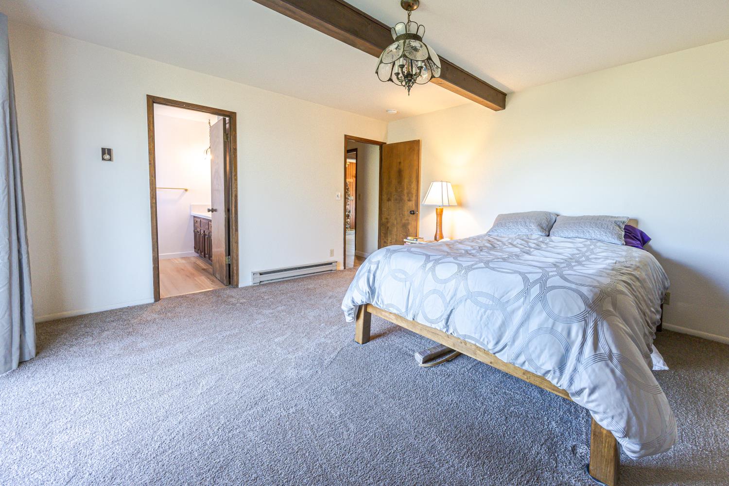 34107 Memory Lane Coarsegold, CA 93614 - Photo 12 of 46 a bedroom with a bed and a chandelier