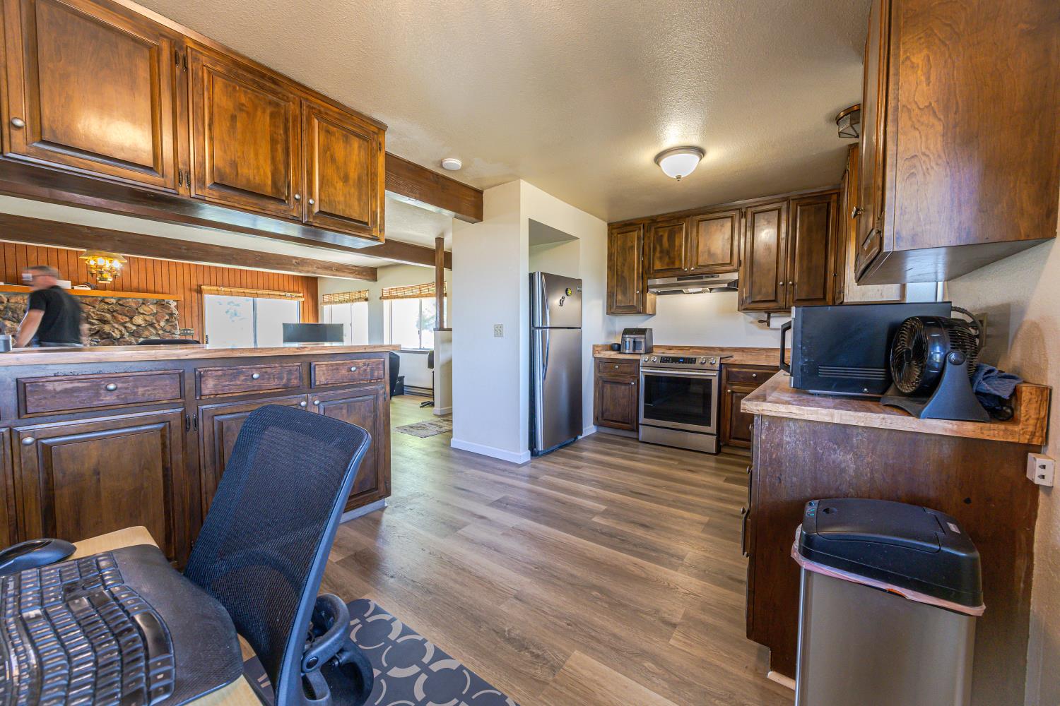 34107 Memory Lane Coarsegold, CA 93614 - Photo 10 of 46 a kitchen with stainless steel appliances granite countertop a refrigerator a stove a sink dishwasher and wooden cabinets with wooden floor