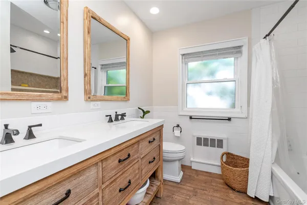 a bathroom with a granite countertop sink mirror and a bathtub