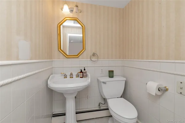 a bathroom with a toilet a sink and mirror