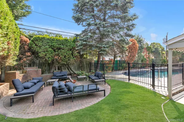 a view of a patio with couches table and chairs and potted plants