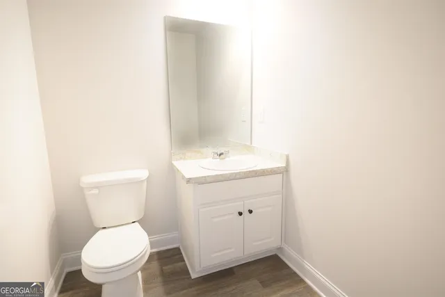 a bathroom with a toilet a sink and mirror