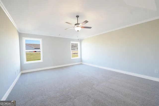 an empty room with windows and chandelier fan