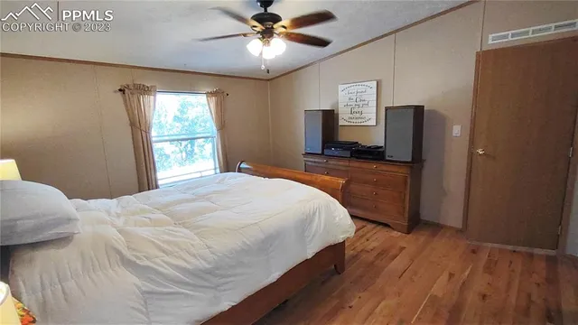 a bedroom with a bed chandelier and a window