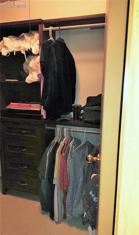 a view of walk in closet with clothes and shoes