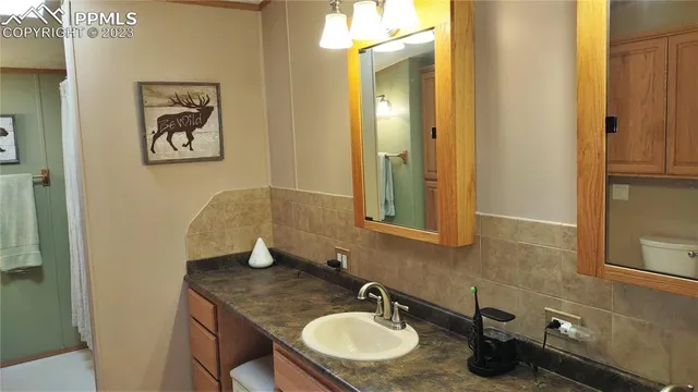 a bathroom with a granite countertop sink a mirror and vanity
