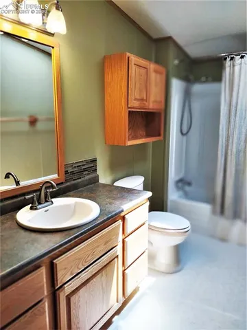 a bathroom with a sink a toilet and mirror