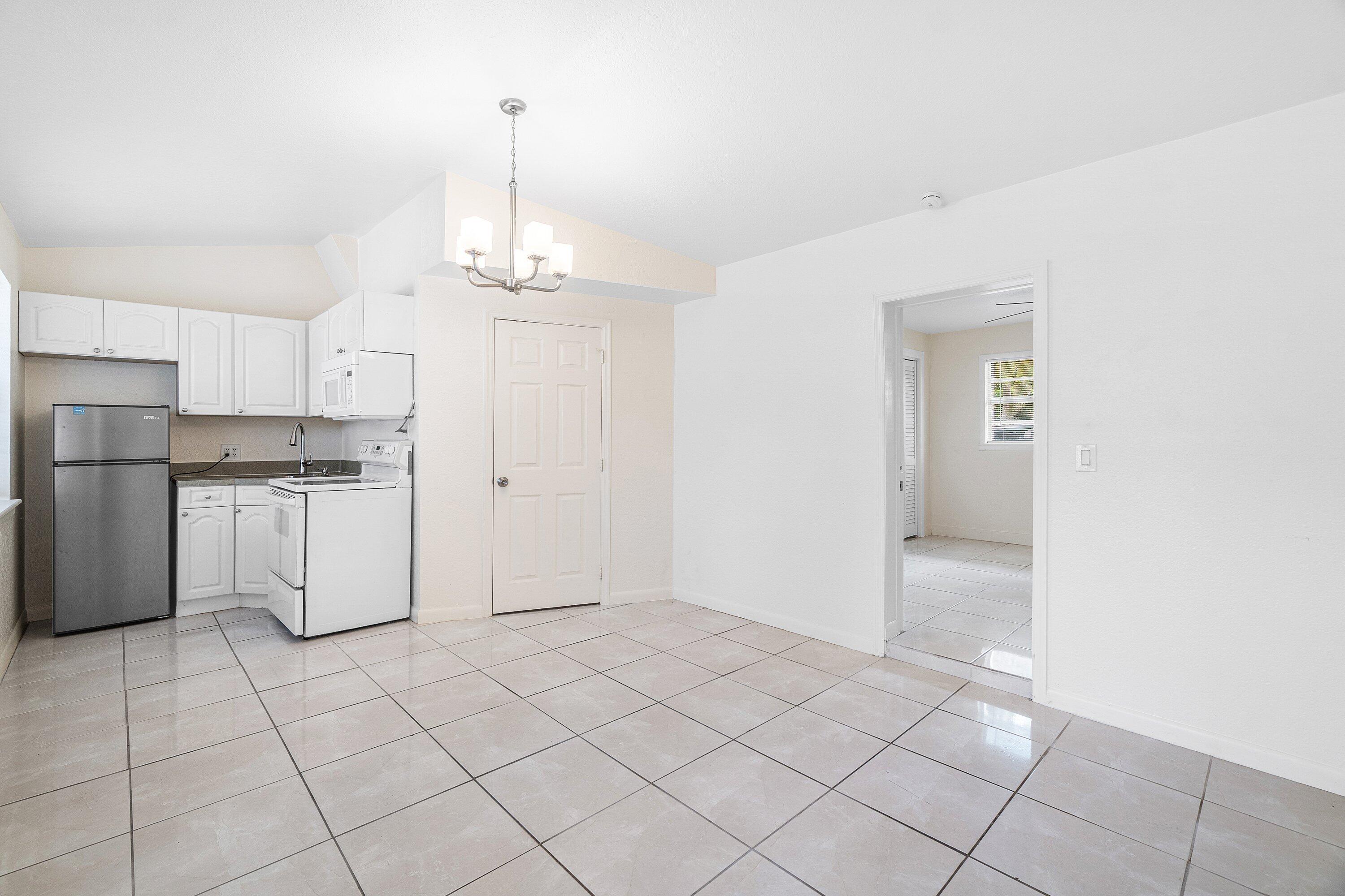 205 Coral Road, Unit 2 Boynton Beach, FL 33435 - Photo 4 of 9 a view of a kitchen with white cabinets and refrigerator