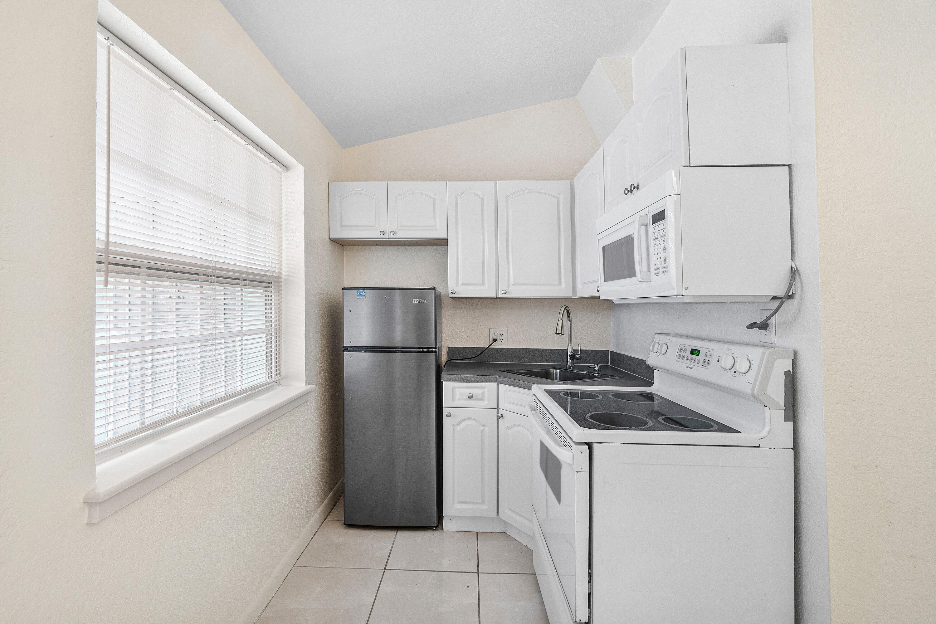 205 Coral Road, Unit 2 Boynton Beach, FL 33435 - Photo 6 of 9 a kitchen with a stove a refrigerator and a window