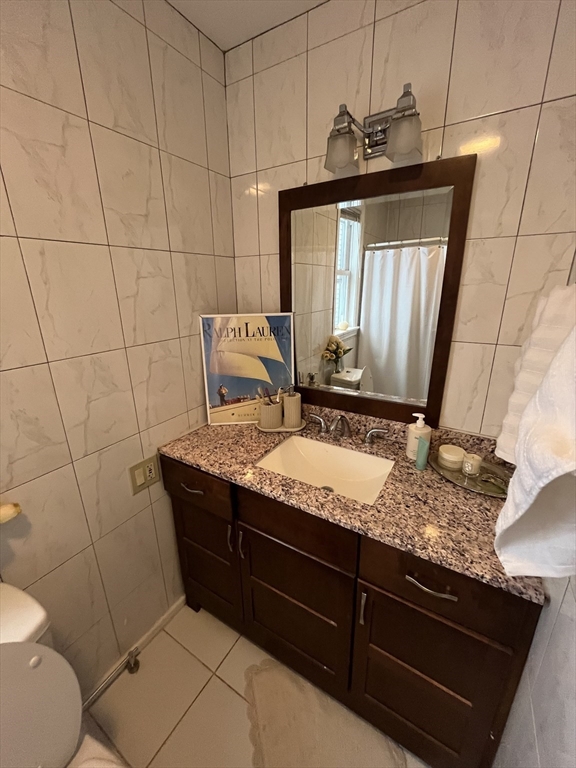 39 O Street, Unit 1 Boston, MA 02127 - Photo 18 of 26 a bathroom with a granite countertop sink a toilet and mirror