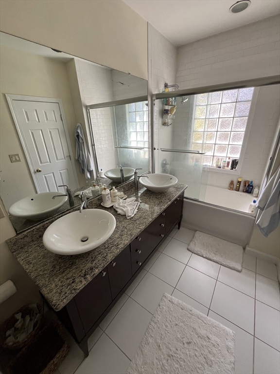 39 O Street, Unit 1 Boston, MA 02127 - Photo 19 of 26 a bathroom with a double vanity sink a mirror and a bathtub