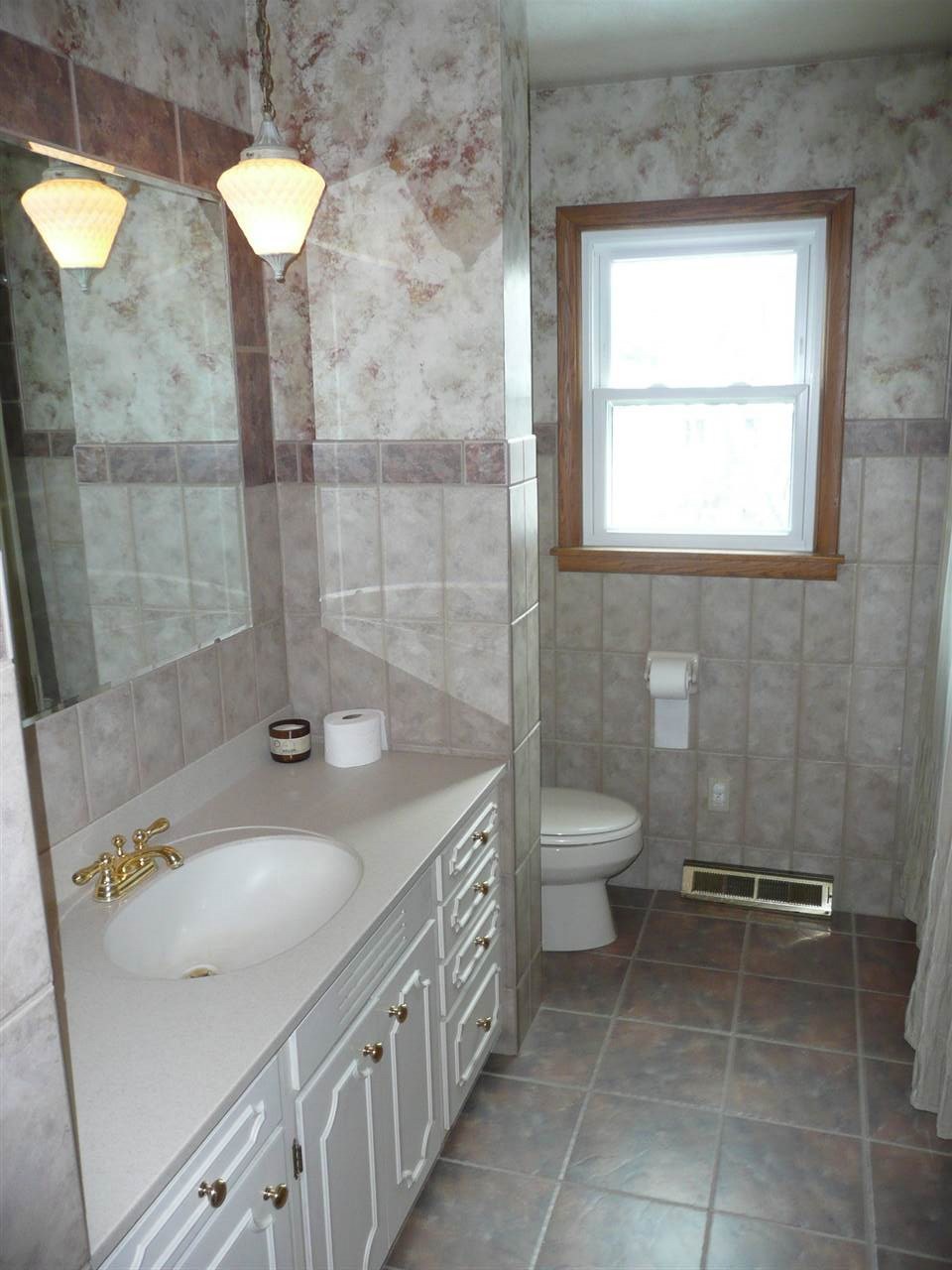 5343 Brookview Road Rockford, IL 61107 - Photo 12 of 22 a bathroom with a granite countertop sink a toilet and a shower