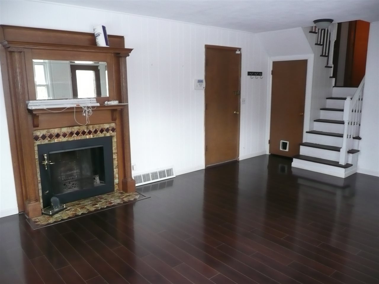 5343 Brookview Road Rockford, IL 61107 - Photo 17 of 22 an empty room with wooden floor a fireplace and windows