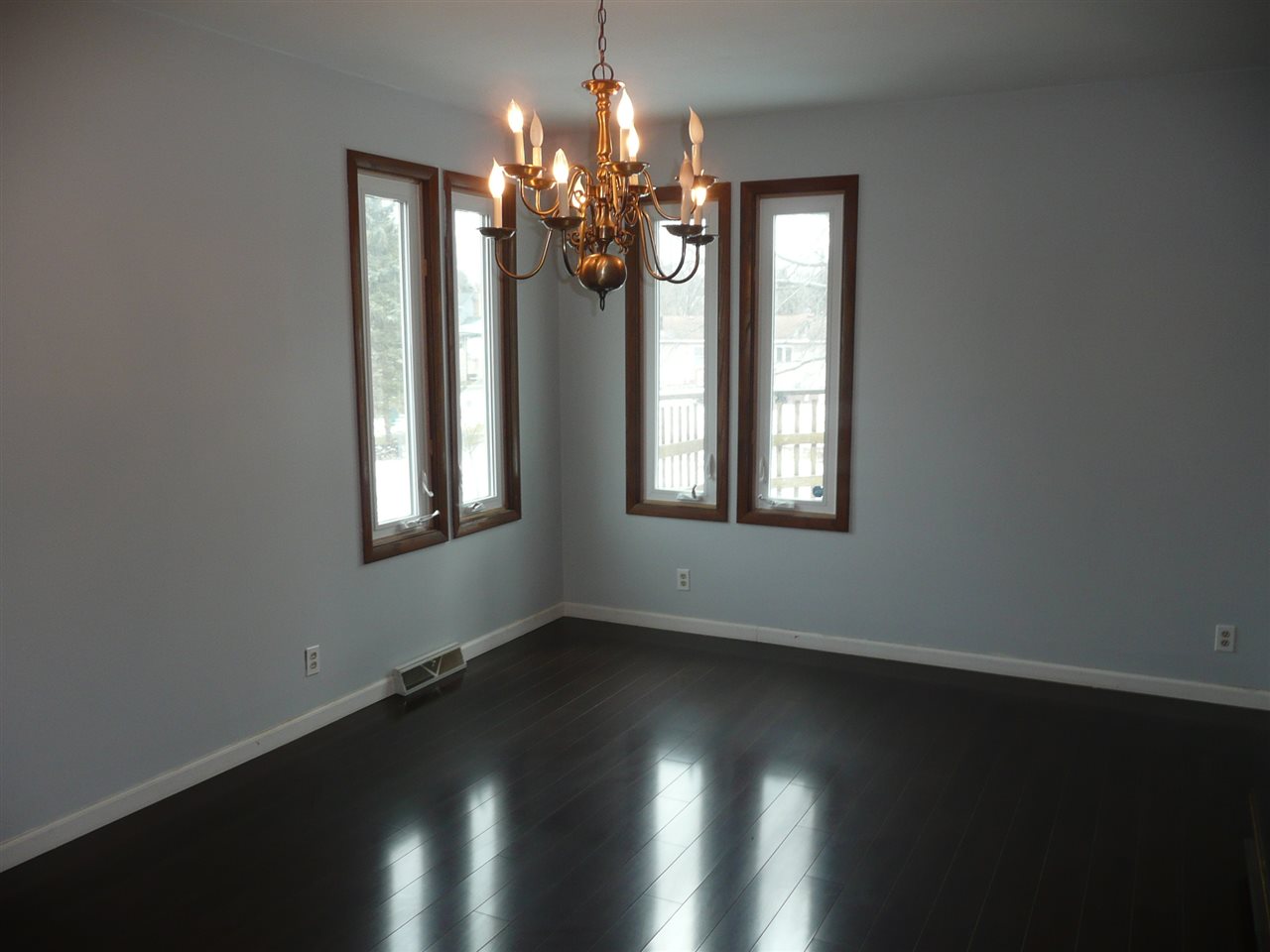 5343 Brookview Road Rockford, IL 61107 - Photo 6 of 22 an empty room with wooden floor chandelier and windows