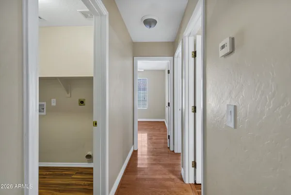 a view of a hallway with wooden floor and closet area