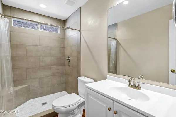 a bathroom with a sink a toilet and shower