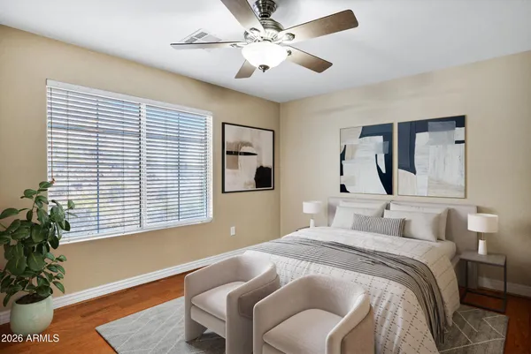 a bedroom with a large bed and a potted plant