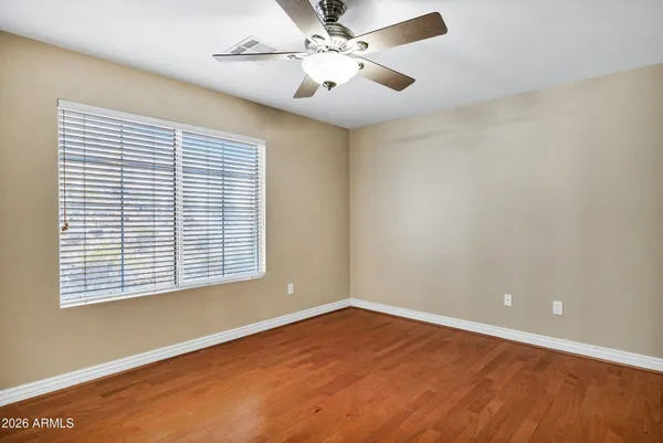 an empty room with a window and a ceiling fan