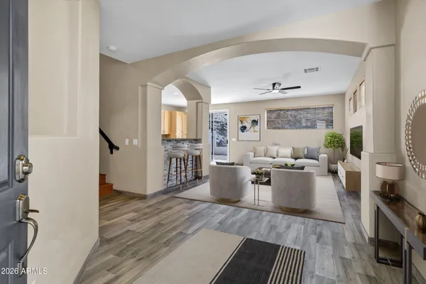a living room with furniture large window and wooden floor