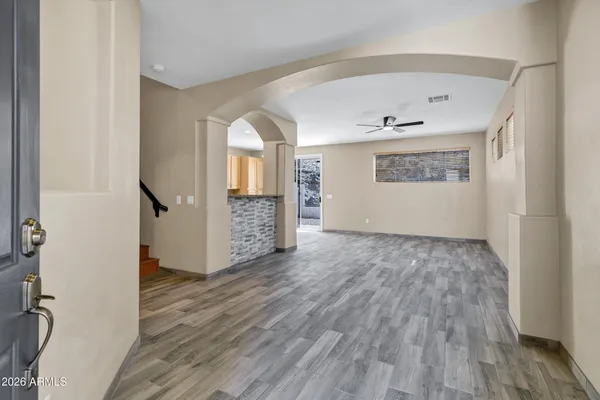 a view of an empty room with wooden floor and a window
