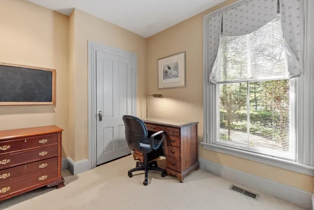 a view of a workspace with furniture and a window