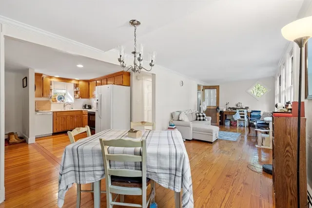 a view of a dining room and livingroom with furniture wooden floor a chandelier