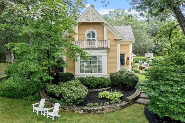 a front view of a house with a yard and trees