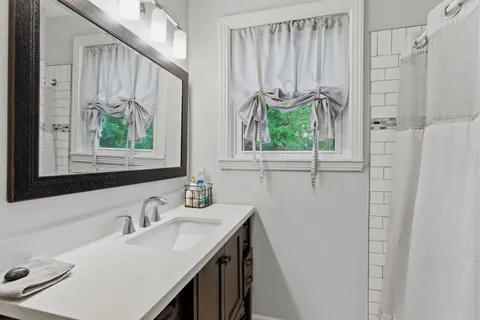 a bathroom with a sink a mirror and a window