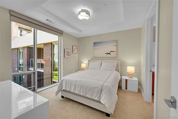 a bedroom with a large bed and a chandelier