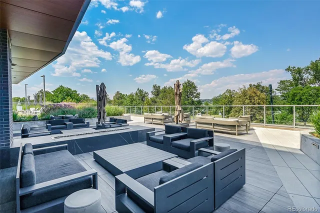 a view of a patio with a dining table and chairs with a large tree