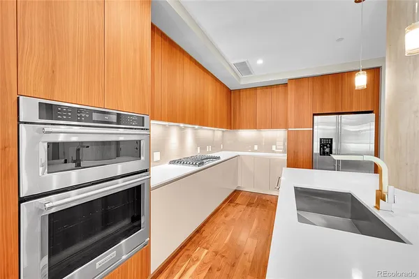 a kitchen with stainless steel appliances wooden cabinets and a stove top oven