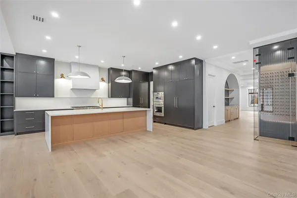 a large kitchen with stainless steel appliances kitchen island a large counter top and a sink