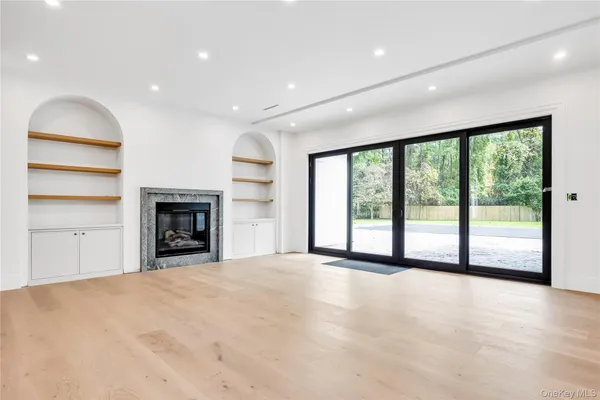 a view of an empty room with a fireplace and a large window